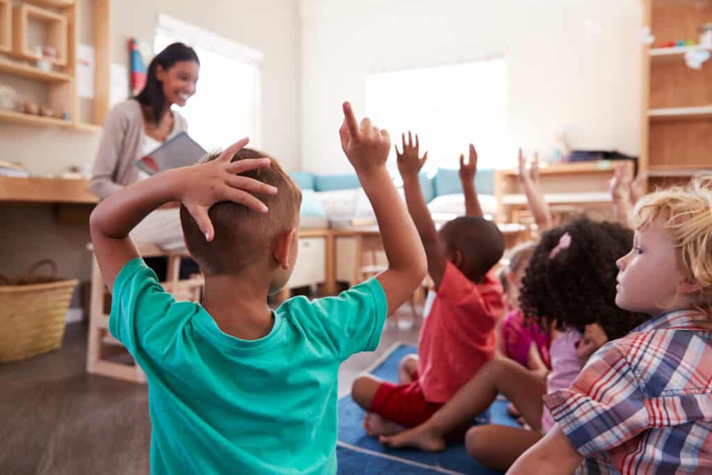 Pupils,At,Montessori,School,Raising,Hands,To,Answer,Question Pupils,At,Montessori,School,Raising,Hands,To,Answer,Question